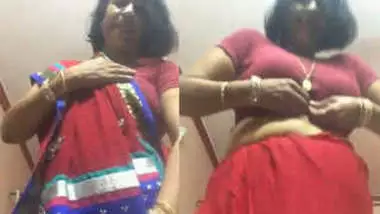 Desi female in a red sex sari flashes her XXX jugs changing the clothes